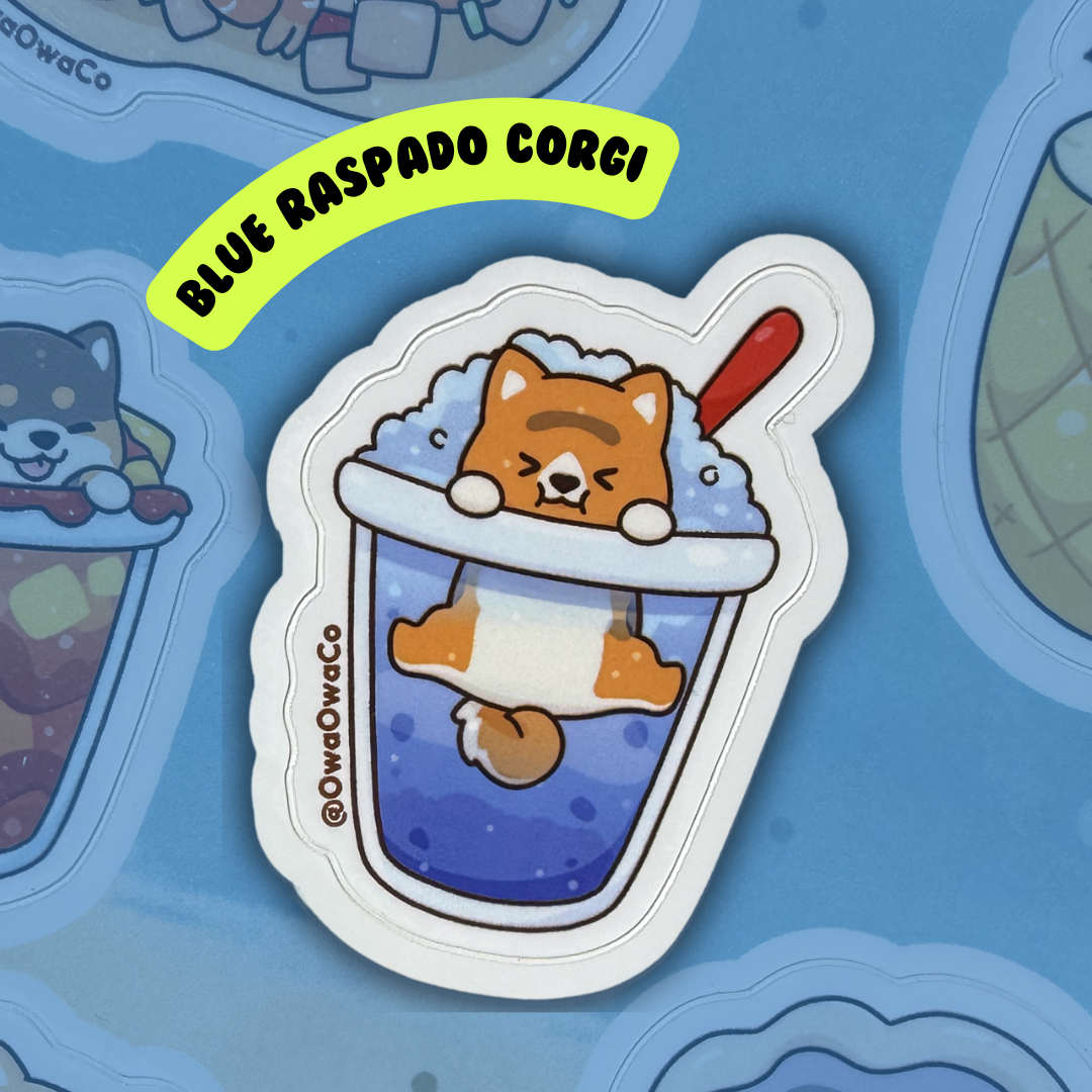 Owa Owa Treatlandia Sticker of a corgi in a blue raspado with ice, branded 'Blue Raspado Corgi', on a blue background.