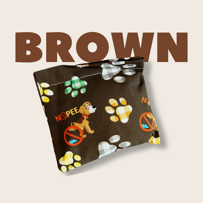 Close-up of brown NOPEE dog urine marking deterrent bag with colorful design